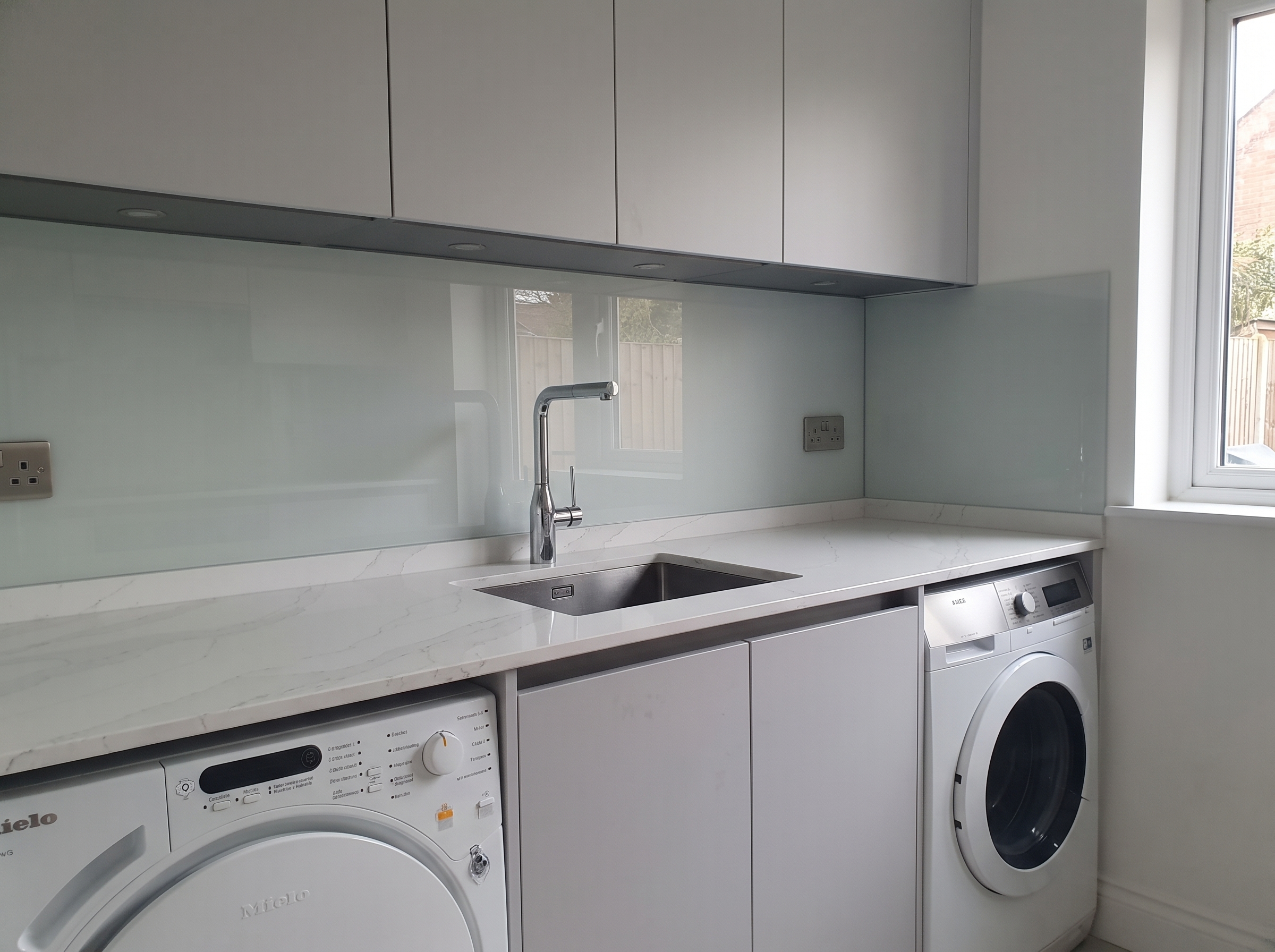 Toughened coloured glass splashback fitted in a Wallington kitchen