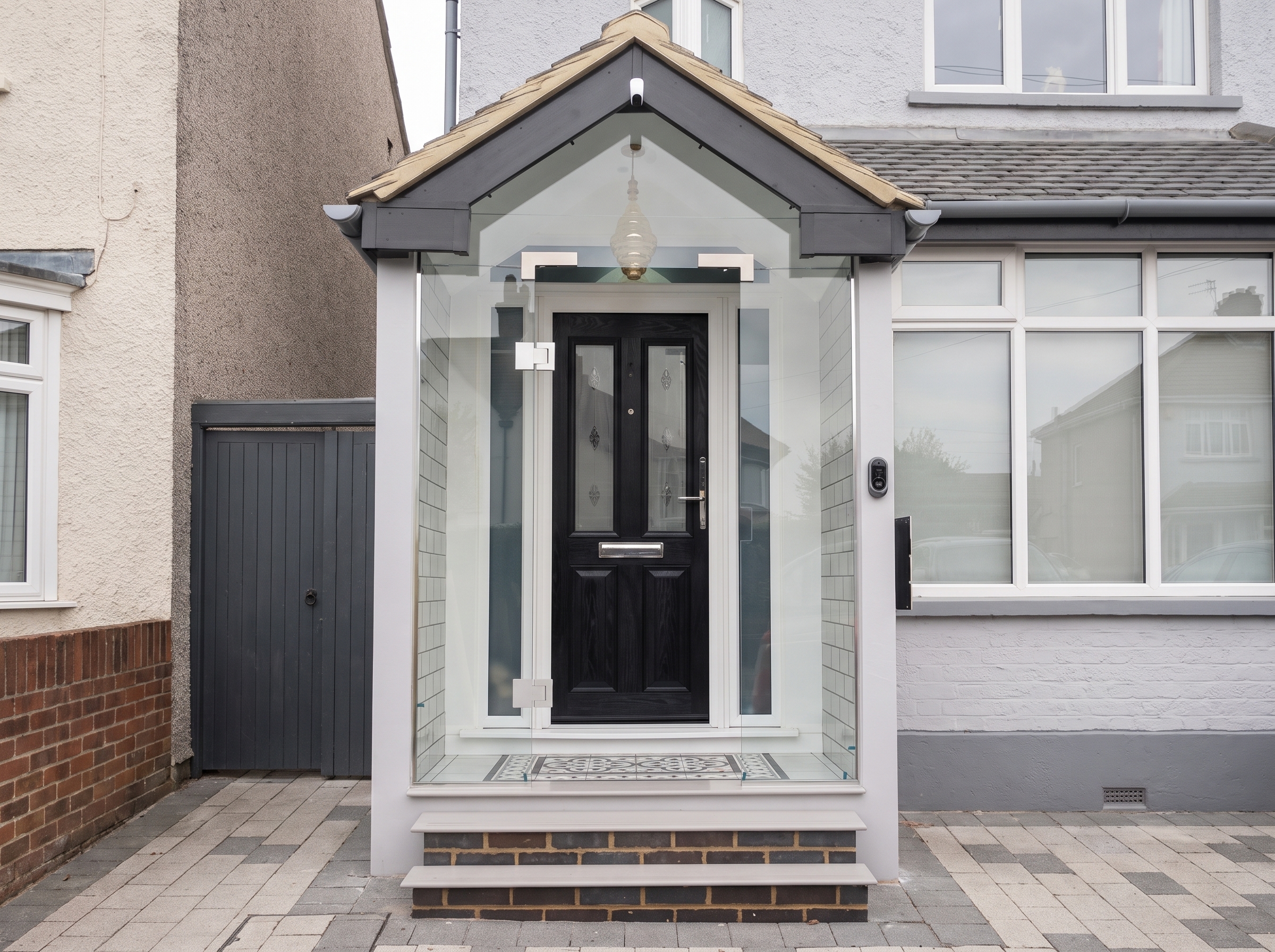 Frameless glass porch enclosure on a tiled step